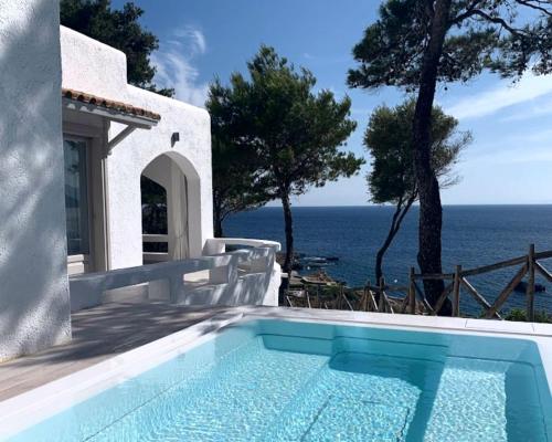 a swimming pool with a view of the ocean at Marpunta Resort, Santikos Collection in Patitiri