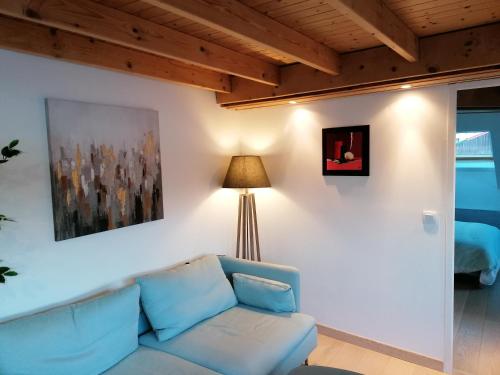 瓦龍的住宿－LE PANORAMA，客厅配有蓝色的沙发和灯具
