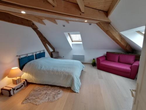 a bedroom with a bed and a couch in a attic at LE PANORAMA in Voiron