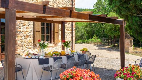 a table set up for a wedding under a wooden pergola at TERRIPI 10, Emma Villas in Pomarance