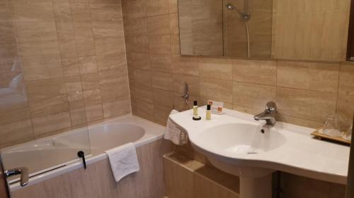 a bathroom with a sink and a bath tub at Le Grand Monarque in Melun