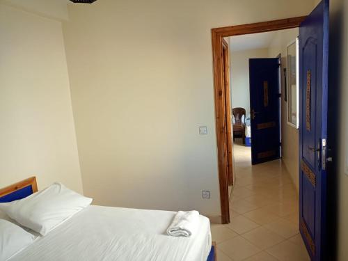 a bedroom with two beds and a hallway at Dar Bouanani in Asilah