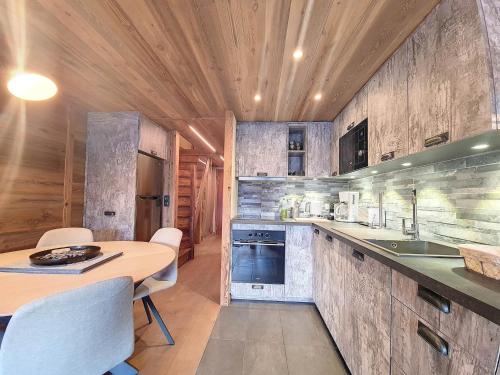 - une cuisine avec un plafond en bois, une table et des chaises dans l'établissement Charmant 2P rénové · Centre Val d'Isère · Proche Pistes · Balcon Sud · Wifi - FR-1-518-129, à Val dʼIsère