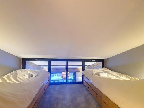 two beds in a room with a window at Charmant 2P rénové · Centre Val d'Isère · Proche Pistes · Balcon Sud · Wifi - FR-1-518-129 in Val dʼIsère