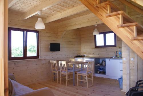 Una cocina con mesa y sillas en una cabaña. en Domek Morski 2C, en Łukęcin