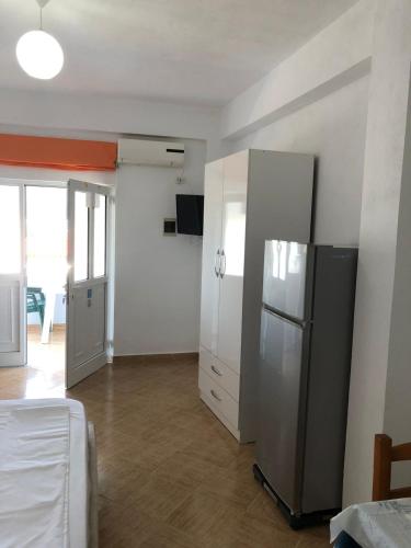 a kitchen with a stainless steel refrigerator in a room at Villa Praljan in Borsh