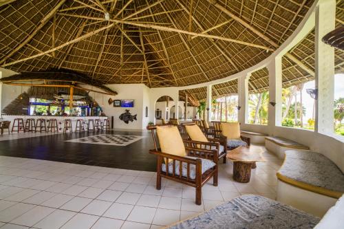 a lobby of a resort with chairs and a bar at Antonio Beach Tree House Hotel & Spa in Uroa