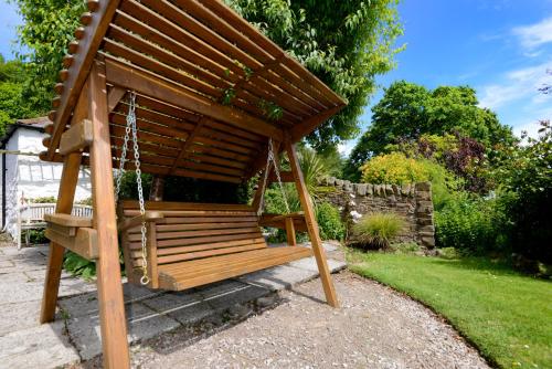 a wooden swing in a garden at Craigadam Lodge with Hot tub in Castle Douglas