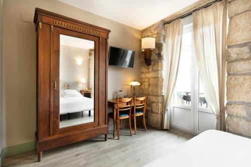 a room with a wooden floor and a wooden dresser at Hotel Okako San Sebastian in San Sebastián