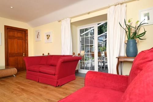 a living room with red furniture and a window at Craigadam Lodge with Hot tub in Castle Douglas
