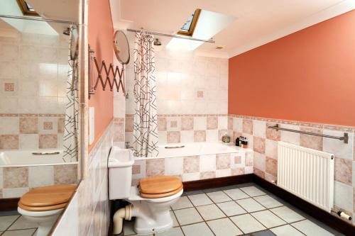 a bathroom with a toilet and a tub at Craigadam Lodge with Hot tub in Castle Douglas