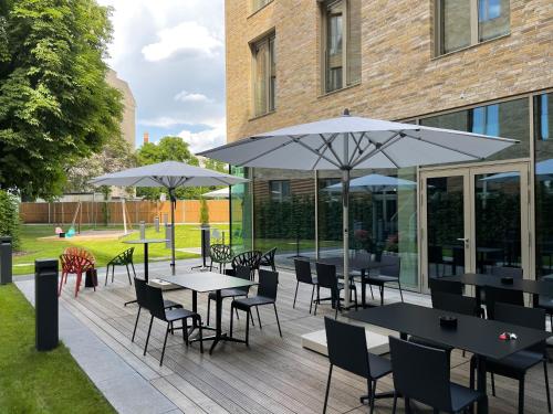 a patio with tables and chairs and umbrellas at aletto Hotel Potsdamer Platz in Berlin