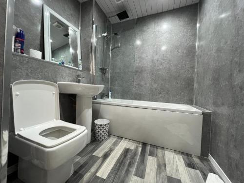 a bathroom with a toilet and a tub and a sink at Lovely one bedroom Apartment in Glasgow City in Glasgow