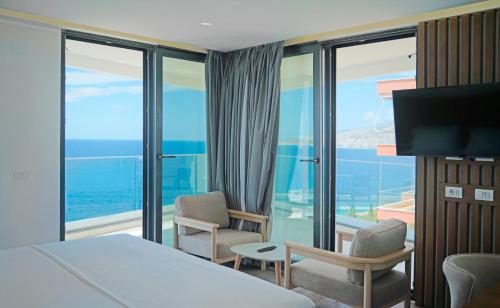 a hotel room with a bed and a view of the ocean at Dorchester Hotel in Sarandë