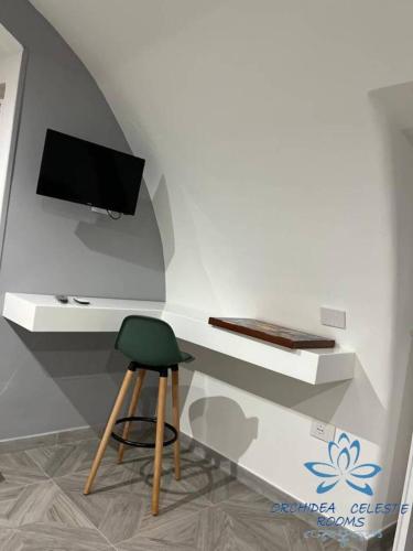 a room with a desk with a chair and a television at B&B Orchidea Celeste in Manfredonia