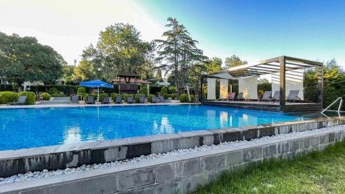 uma piscina com um gazebo num quintal em PİA MARE OTEL em Gündüzlü