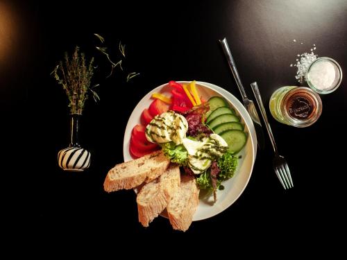 a plate of food with vegetables and bread on a table at aletto Hotel Potsdamer Platz in Berlin