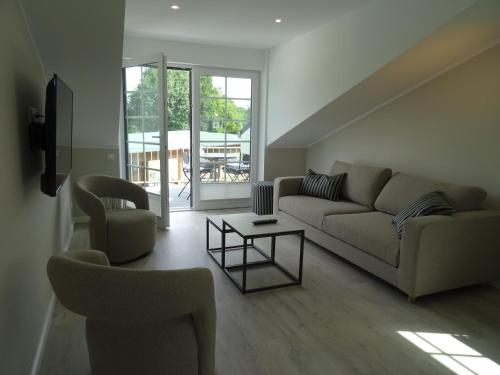 a living room with a couch and two chairs and a table at Ferienwohnung Judith Jensen in Wrohm