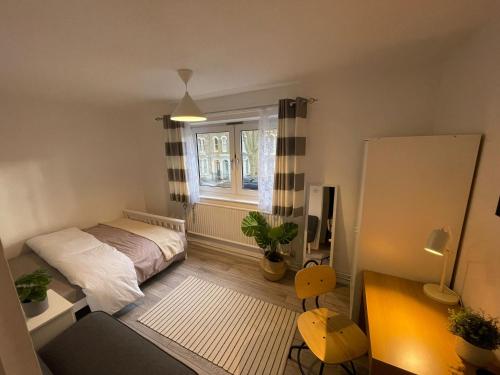 a small bedroom with a bed and a window at Bow House - SleepyLodge in London