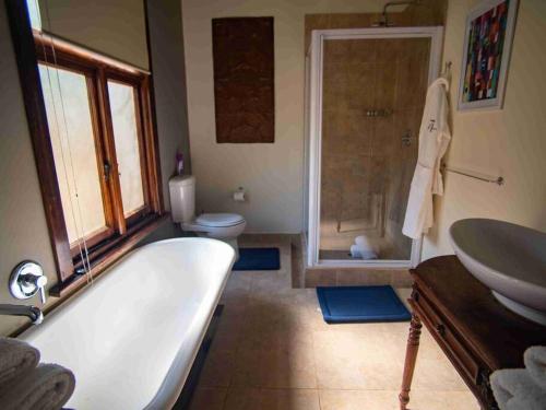 a bathroom with a tub and a toilet and a sink at 74 on retief Guesthouse in Potchefstroom