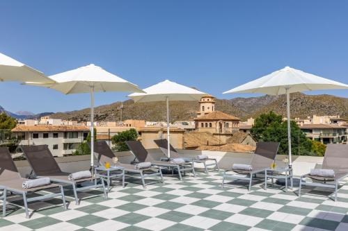a group of chairs and umbrellas on a patio at Hoposa Cultural Boutique in Port de Pollensa