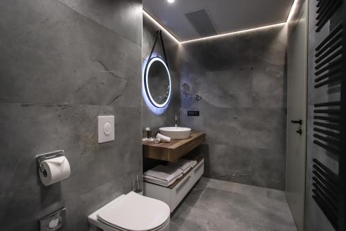 a bathroom with a sink and a toilet and a mirror at Hotel Medistone in Omiš