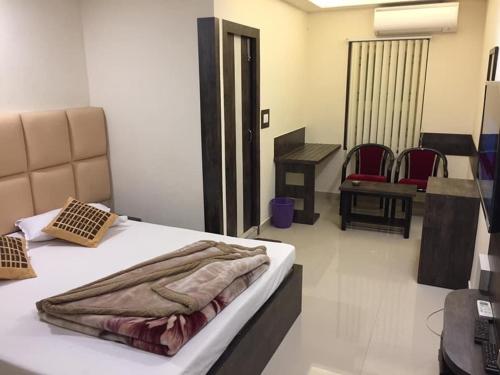 a bedroom with a bed with a blanket on it at Atithi Guest House in Siliguri