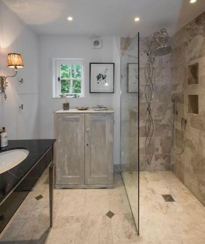 a bathroom with a shower and a sink at The Old Post Office in Broadway