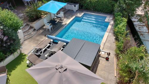 an overhead view of a swimming pool with a table and umbrella at Pavillon Kalensa in Vals-les-Bains