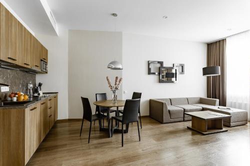 a kitchen and living room with a table and a couch at Senator Maidan in Kyiv