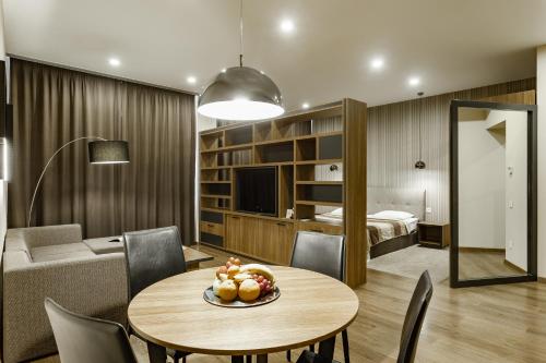 a living room with a table and a bedroom at Senator Maidan in Kyiv