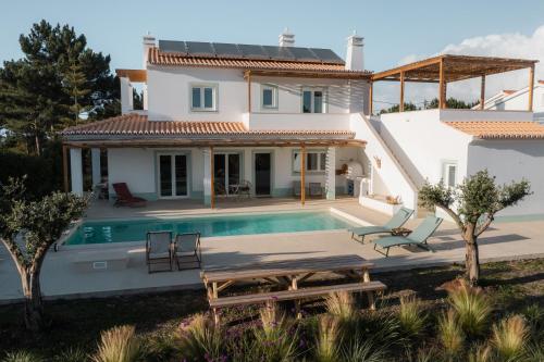 uma villa com uma piscina e uma casa em Birds of Paradise em Aljezur