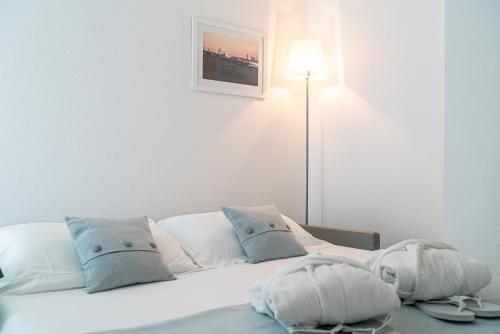 a white bed with two pillows and a lamp at Hotel Bellavista in Lignano Sabbiadoro