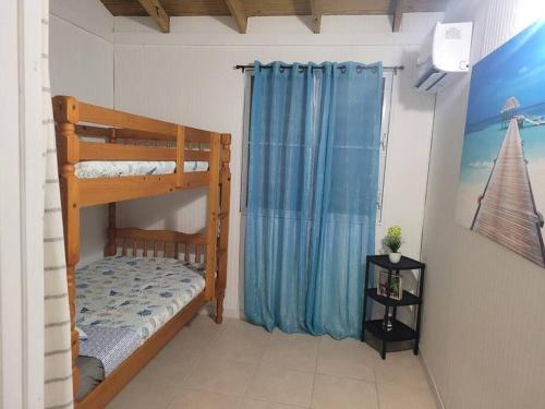 1 dormitorio con litera y cortina azul en Villa zoe house near rincon, en Anasco