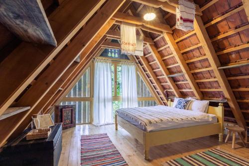sypialnia z łóżkiem i dużym oknem w obiekcie Viscri 32 - White Barn and Blue House w mieście Viscri