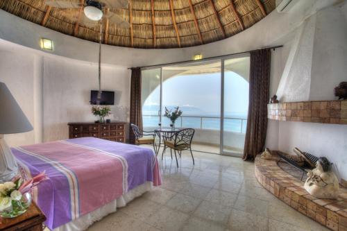 a bedroom with a bed and a view of the ocean at Villa Azul in Puerto Vallarta