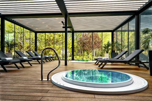 a hot tub in the middle of a deck with chairs at Artis Loft Hotel in Radziejowice