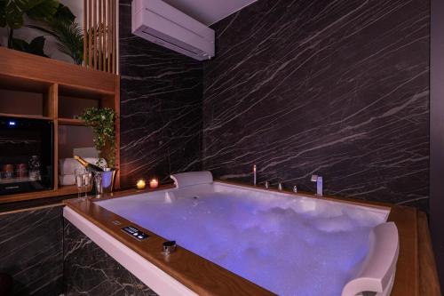 a large bath tub in a bathroom with black marble at 7heaven pontevecchio rooms in Florence