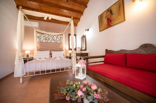 a living room with a red couch and a bed at Hovolo Hotel Apartments in Neo Klima