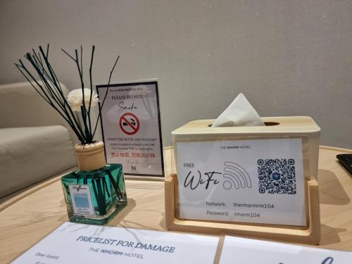a table with a box and a sign on it at The Nhorm Hotel Ratchada in Bangkok