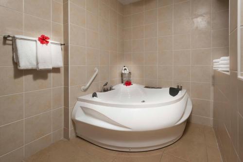 a white toilet sitting in a bathroom next to a bath tub at Divi Little Bay Beach Resort in Philipsburg