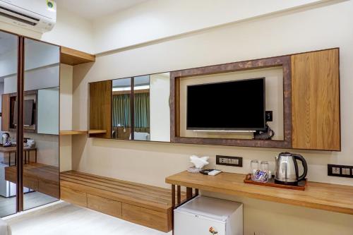 ムンバイにあるHotel Oltenの壁にテレビが付いたホテルルーム