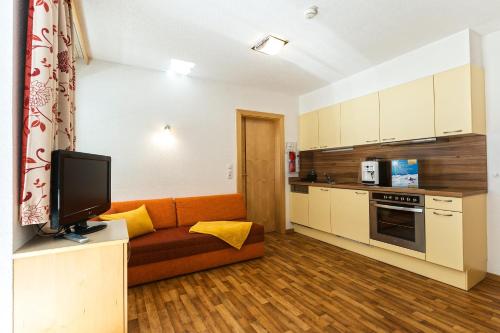 a living room with a couch and a kitchen at Apart Garni Astrada in Kappl