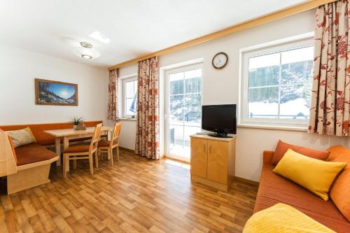 a living room with a couch and a table at Apart Garni Astrada in Kappl