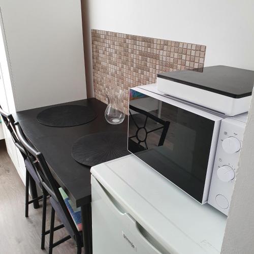 a microwave oven sitting on top of a table at ARANY13 Apartmanház - Mówimy po polsku! in Bogács