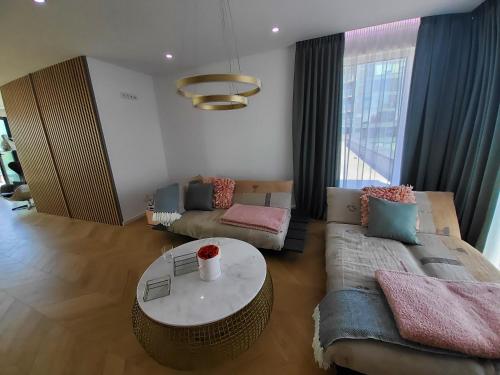 a living room with a couch and a table at Luxury Penthouse Rzeszów in Rzeszów