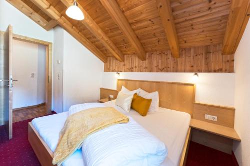 two beds in a room with wooden ceilings at Apart Garni Astrada in Kappl