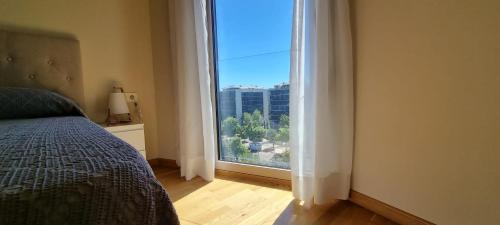 Un dormitorio con una cama y una ventana grande. en APARTAMENTO CAMP DE MORVEDRE, en Castellón de la Plana