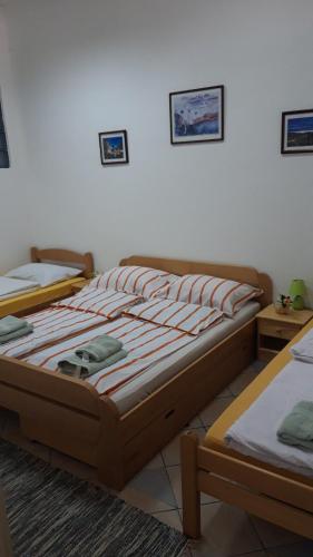 two twin beds in a room with a white wall at Apartment and rooms"Tabašnice"Tuzla centar in Tuzla