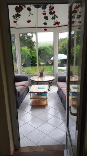 a screened in porch with a couch and a table at 14-18 Somme Chambres in Beaucourt-sur-lʼAncre